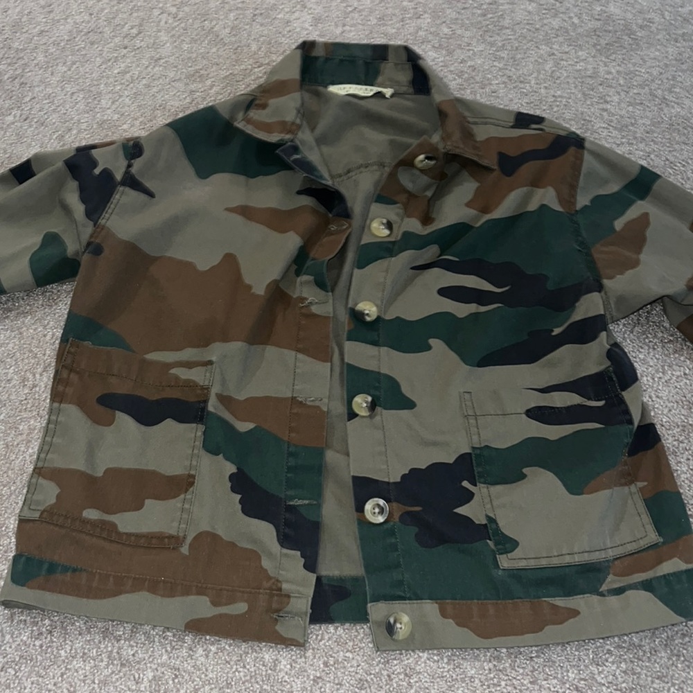 Camouflage button up jean jacket with pockets on both sides on front.